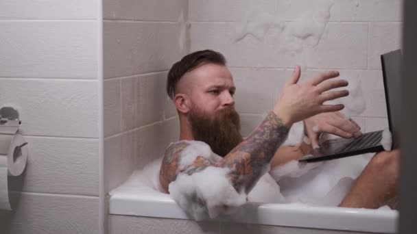 Homme travaille à la maison dans la salle de bain vidéoconférence tapant sur la quarantaine clavier — Video