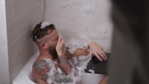 Homem trabalha em casa no banheiro vídeo conferência digitação no teclado quarentena — Vídeo de Stock