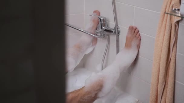 Ноги у ванній кімнаті в пінопласті, натикаючись на стіну — стокове відео