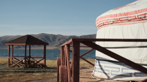 Yurt solitário em um lugar pitoresco de lago bonito, em montanhas distantes — Vídeo de Stock