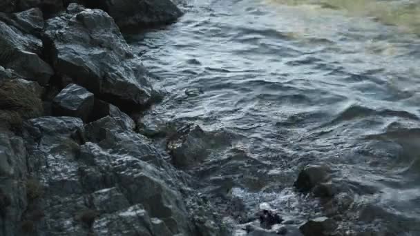 Piękne malownicze błękitne jezioro, woda na brzegu bije o skały, — Wideo stockowe