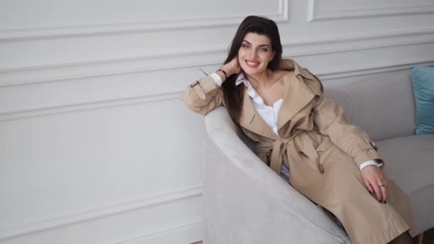 Odnosząca sukcesy kobieta biznesu w kremowym płaszczu przeciwdeszczowym patrząc w kamerę, portret — Wideo stockowe