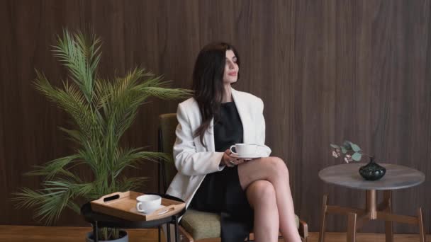 Femme d'affaires réussie Assis sur la chaise à boire du café ou du thé au bureau — Video