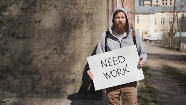 Mann mit Schild, brauchen Arbeit, Arbeitslose.Banner für Jobsuche.Finanzkrise — Stockvideo