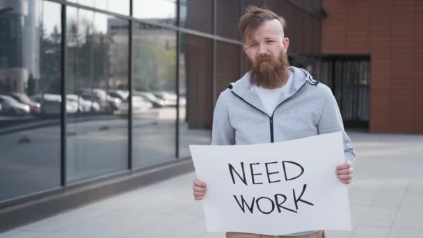 Mężczyzna trzyma znak, potrzebuje pracy, bezrobocia.Baner do poszukiwania pracy.kryzys finansowy — Wideo stockowe