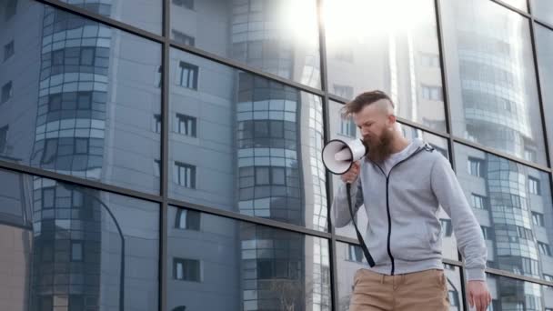 Jong activist, schreeuwt in luidspreker in de buurt van glazen gebouw financiële crisis, rally — Stockvideo