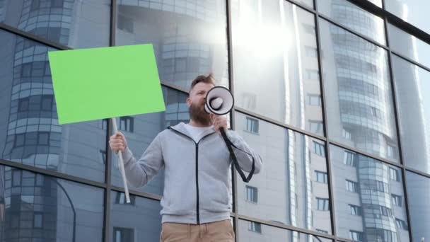 Jeune militant, crie dans haut-parleur près de verre bâtiment crise financière, rassemblement — Video