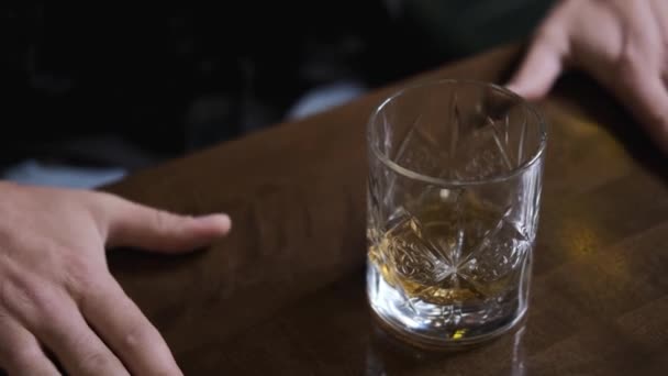 Пьяный мужчина стучит в стол руками, злится, пьет алкоголь — стоковое видео