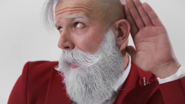 Piękny Święty Mikołaj, trzymając się za rękę przy uchu i słuchając uważnie — Wideo stockowe
