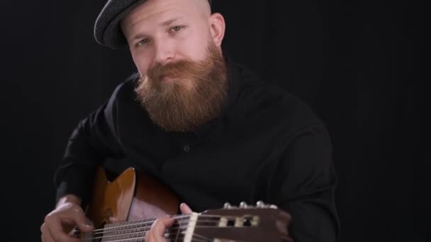 Homem toca guitarra, jovem artista, guitarra acústica, fundo preto — Vídeo de Stock