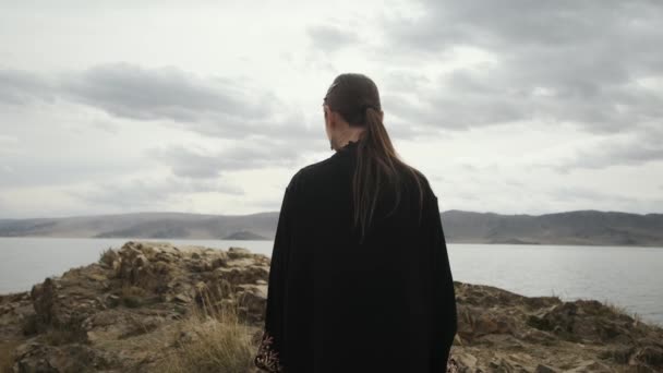 Femme marche au bord de la falaise au sommet de mountain.view par derrière — Video