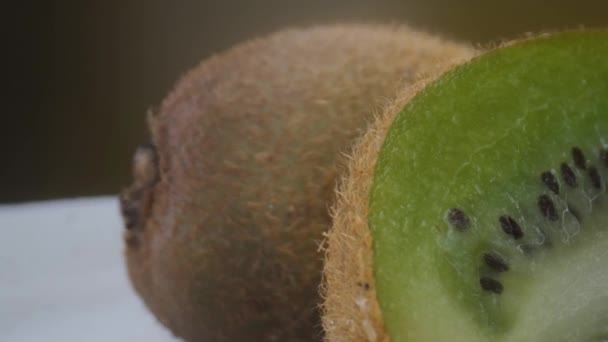 Kiwi buah tembakan makro, terisolasi setengah kiwi pada latar belakang kuning berputar — Stok Video