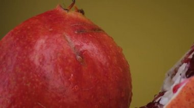 Nar meyveli makro atış, sarı arka planda izole edilmiş yarım kivi.