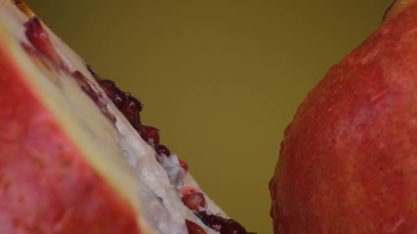 Granatapfelfrucht Makroaustrieb, vereinzelte Hälfte Kiwi auf gelbem Hintergrund dreht sich — Stockvideo