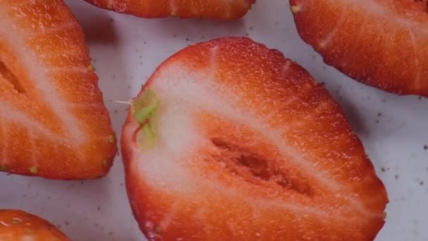 Geschnittene Erdbeere rotierend, isolierte halbe Erdbeere auf weißem Hintergrund — Stockvideo
