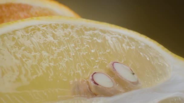 Tournage macro citron et orange, demi-fruit isolé sur fond jaune tourne — Video