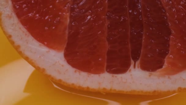 Grapefruitové makro fotografování, izolované půl grapefruitu na žlutém pozadí otáčí — Stock video