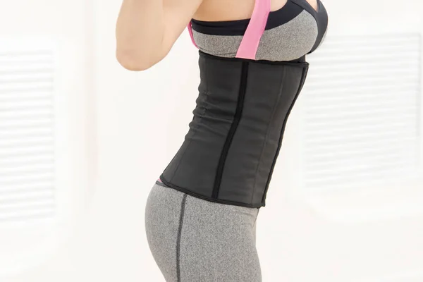 girl at the side in a corset and sports leggings