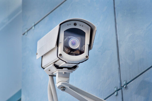 outdoor surveillance camera on the blue wall