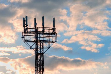 bulutlu bir gökyüzüne karşı antenlerle iletişim direği