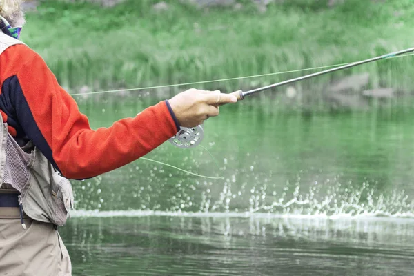 釣竿を持った漁師が魚を巧みに引っかける 川の夏の日の夏の釣り — ストック写真