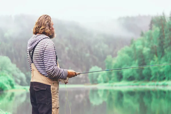 釣竿を持った男が岸で釣りをしていた 川の上の漁師魚は — ストック写真