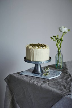 bir kek cakestand üzerine fındık ve zemin rosemary ile dekore edilmiştir.