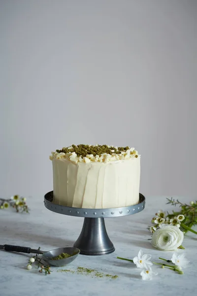 A cake on the cakestand decorated with nuts and ground rosemary — Stock Photo, Image