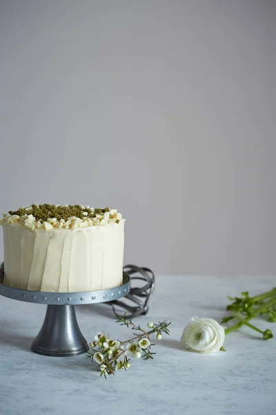 A cake on the cakestand decorated with nuts and ground rosemary — Stock Photo, Image