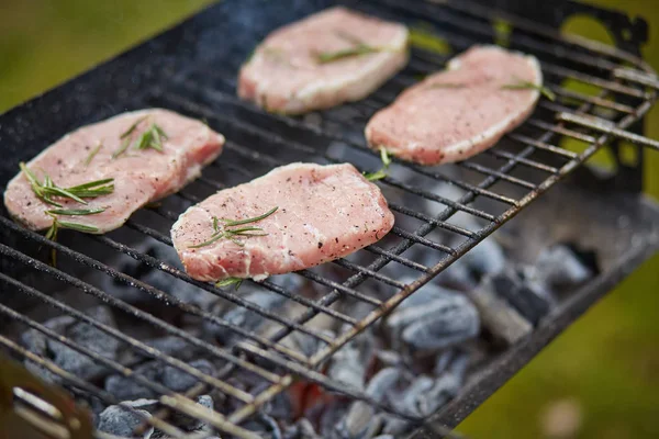Four raw steaks on the grill — Stock Photo, Image