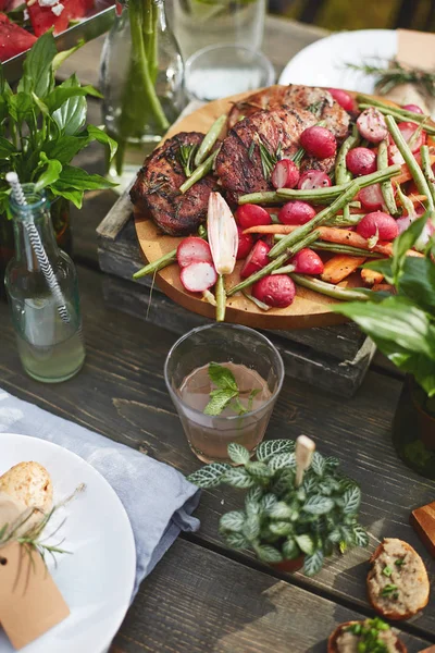 ラウンド木製コースターで野菜と肉のグリル — ストック写真