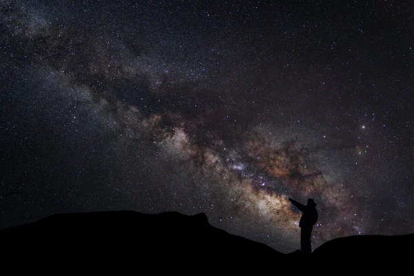 A Man berdiri di samping galaksi cara susu menunjuk pada bintang terang — Stok Foto
