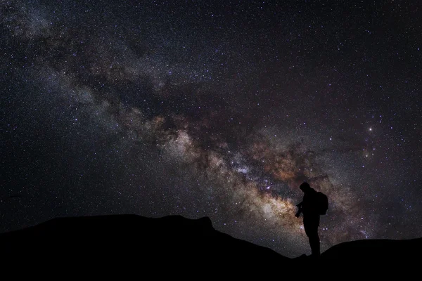 Paisaje con Vía Láctea, Cielo nocturno con estrellas y silueta de un fotógrafo de pie — Foto de Stock