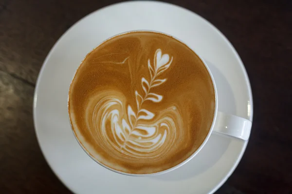 Widok z góry latte art kawy na tle drewna — Zdjęcie stockowe