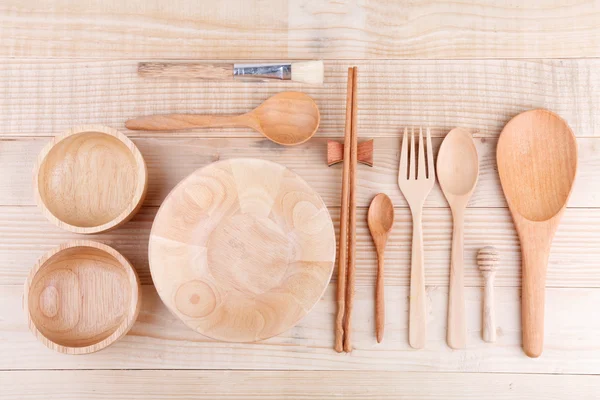 Various wooden kitchen utensils on wood table. top vie