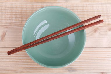 Ahşap arka plan üzerinde Asya küme tablosundaki chopsticks