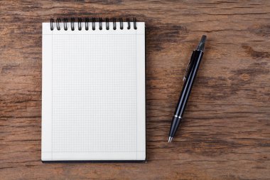 Ahşap arka plan üzerinde kalem ile boş not defteri