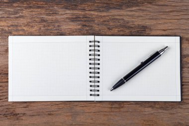 Ahşap arka plan üzerinde kalem ile boş not defteri