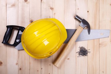 ahşap arka plan üzerinde çekiç ve sarı kask