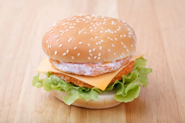 Hamburger z kurczaka i sera na tle drewna — Zdjęcie stockowe