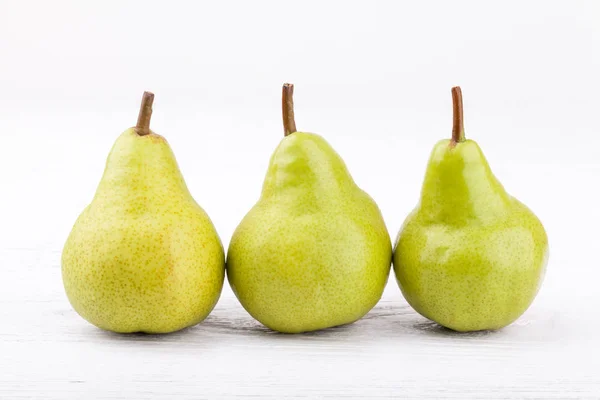 Green pears on white wooden background — Stock Photo, Image