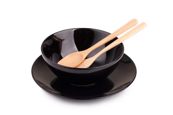 Black ceramic bowl and wooden spoon — Stock Photo, Image