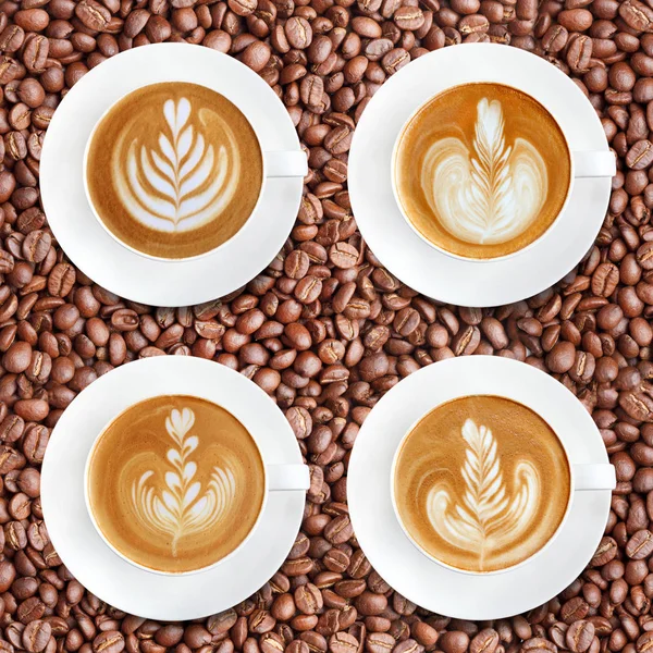 Latte art coffee on roasted coffee beans background — Stock Photo, Image