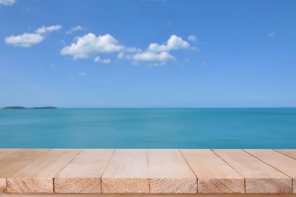 Wood table top on blurred blue sea with cloud background — Stock Photo, Image