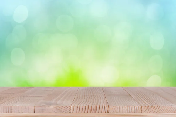 Piano del tavolo in legno marrone su sfondo verde astratto bokeh - può essere utilizzato per visualizzare i tuoi prodotti — Foto Stock
