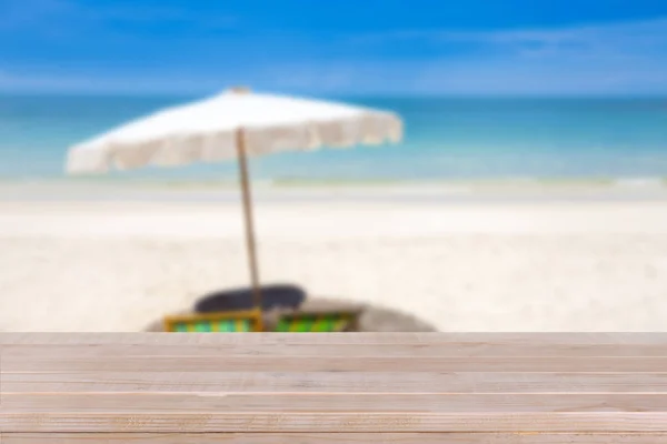 Дерев'яна стільниця на розмитому синьому морі та білому піщаному пляжі фоні — стокове фото