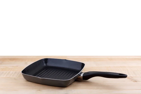 Empty grill pan on wooden table — Stock Photo, Image