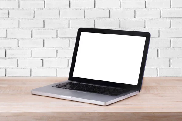 Vista frontal de la computadora portátil está en la mesa de trabajo y el ladrillo blanco ba —  Fotos de Stock