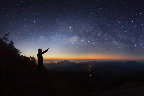 Un hombre está de pie junto a la galaxia de la Vía Láctea apuntando a una estrella brillante en Doi Inthanon — Foto de Stock