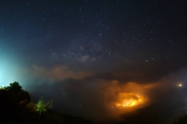 Milky way galaxy over foggy mountains at Phutabberk Phetchabun  clipart